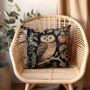Op de afbeelding: Een kussen met een donkere achtergrond met een gedetailleerd tapijtontwerp van een uil die op een tak zit met bloemen en bladeren. De tekst "JOY OF PLANTS Original Fine Art Woven Pillow" is onder het kussen gedrukt.