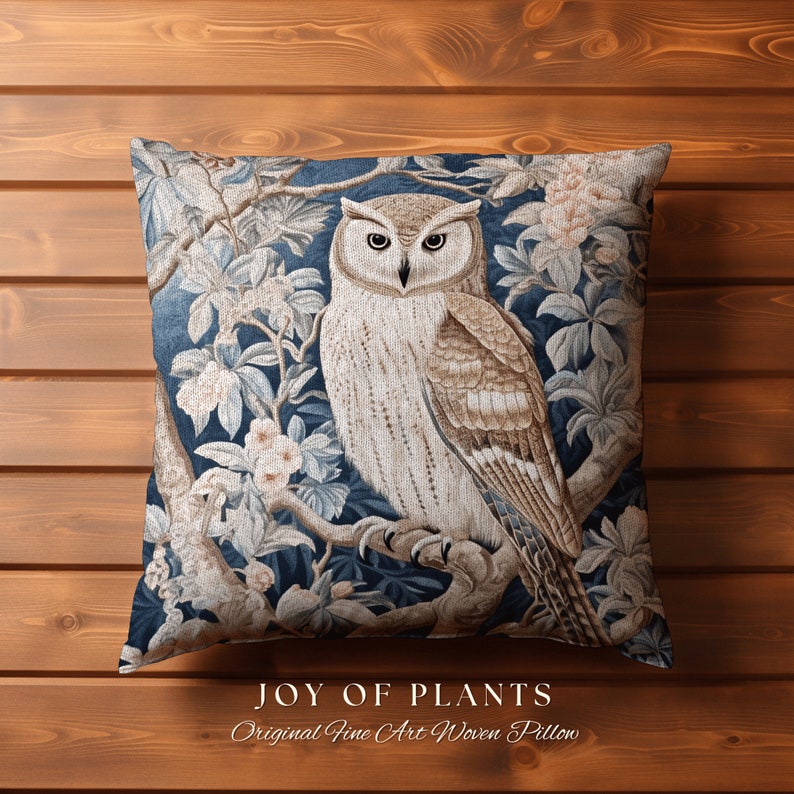 May include: A decorative throw pillow featuring a tapestry-style design of an owl perched on a branch with flowers. The background is a deep blue color. The text "JOY OF PLANTS Original Fine Art Woven Pillow" is printed below the image.