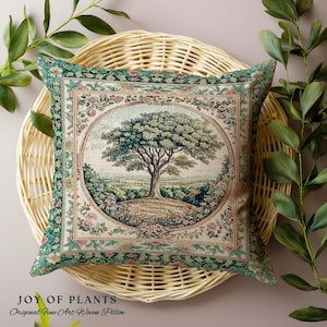 May include: Square cushion with a detailed tree and landscape design. The cushion features a central oval image of a tree on a hill, surrounded by floral and geometric borders in shades of green, pink, and beige. The text "JOY OF PLANTS" is at the bottom.