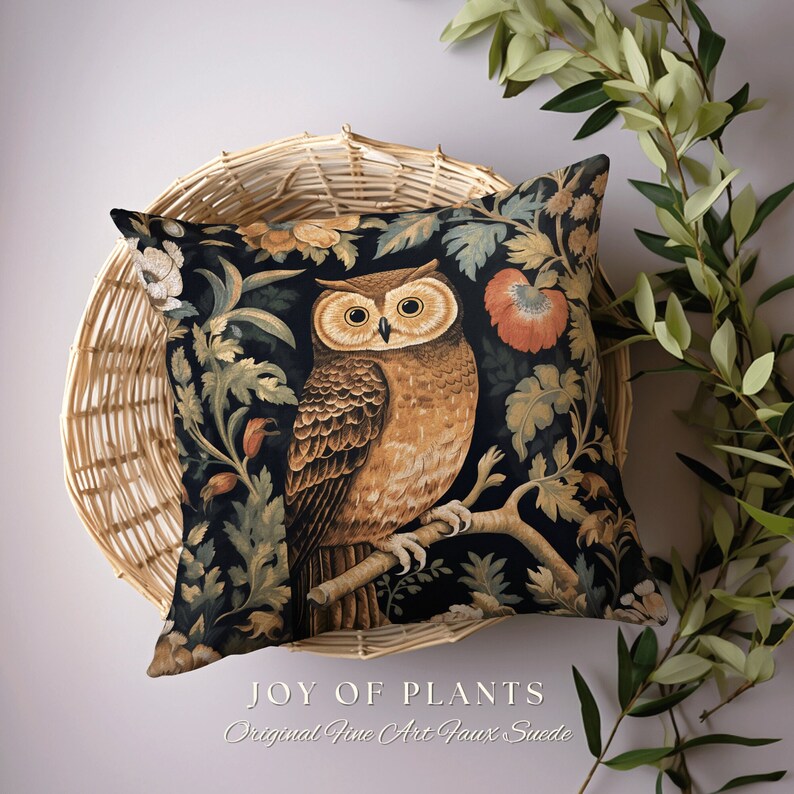 Op de afbeelding: Een decoratief kussen met een donkere achtergrond waarop een gedetailleerde illustratie van een uil op een tak zit, omringd door gestileerde planten en bloemen. De tekst "JOY OF PLANTS Original Fine Art Faux Suede" is onder de afbeelding gedrukt.