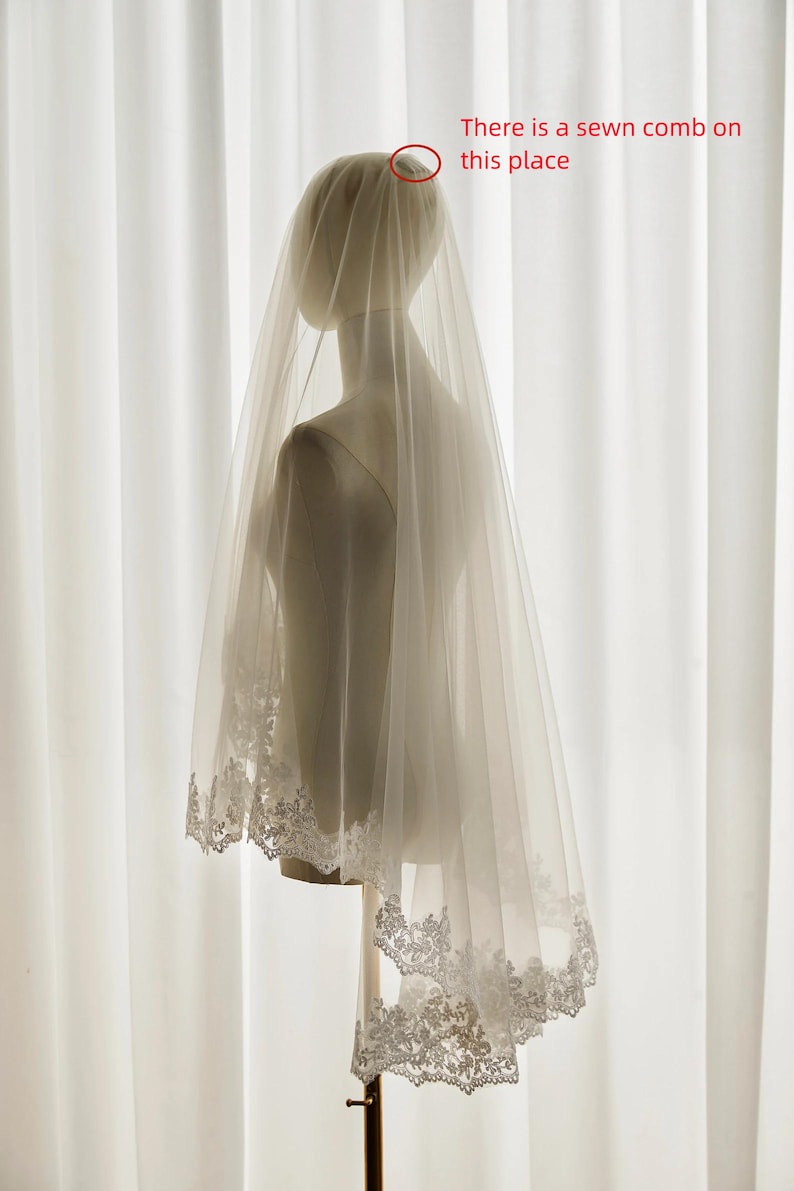 May include: A white bridal veil with a delicate lace trim. The veil is attached to a comb for easy placement in the hair.