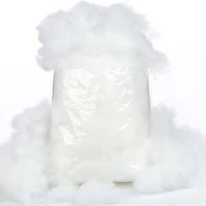 May include: A white plastic bag filled with white fluffy stuffing. The bag is surrounded by loose white stuffing.