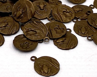 May include: A collection of bronze-colored metal charms featuring a frog design. Each charm has a loop for attaching to a necklace, bracelet, or other jewelry.