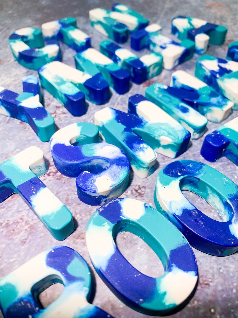May include: A selection of resin letters and numbers in blue, teal, and white. The marbled effect gives a unique look. These decorative pieces are suitable for crafting or personalised gifts. Measurements are in centimetres.