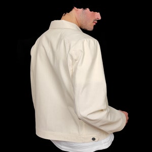 May include: A cream-colored denim jacket with a button closure and long sleeves.