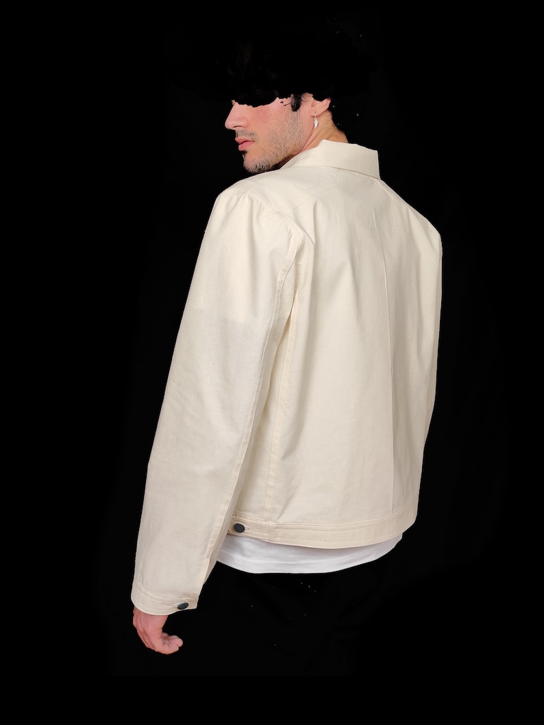 May include: A cream colored denim jacket with a button closure and long sleeves.