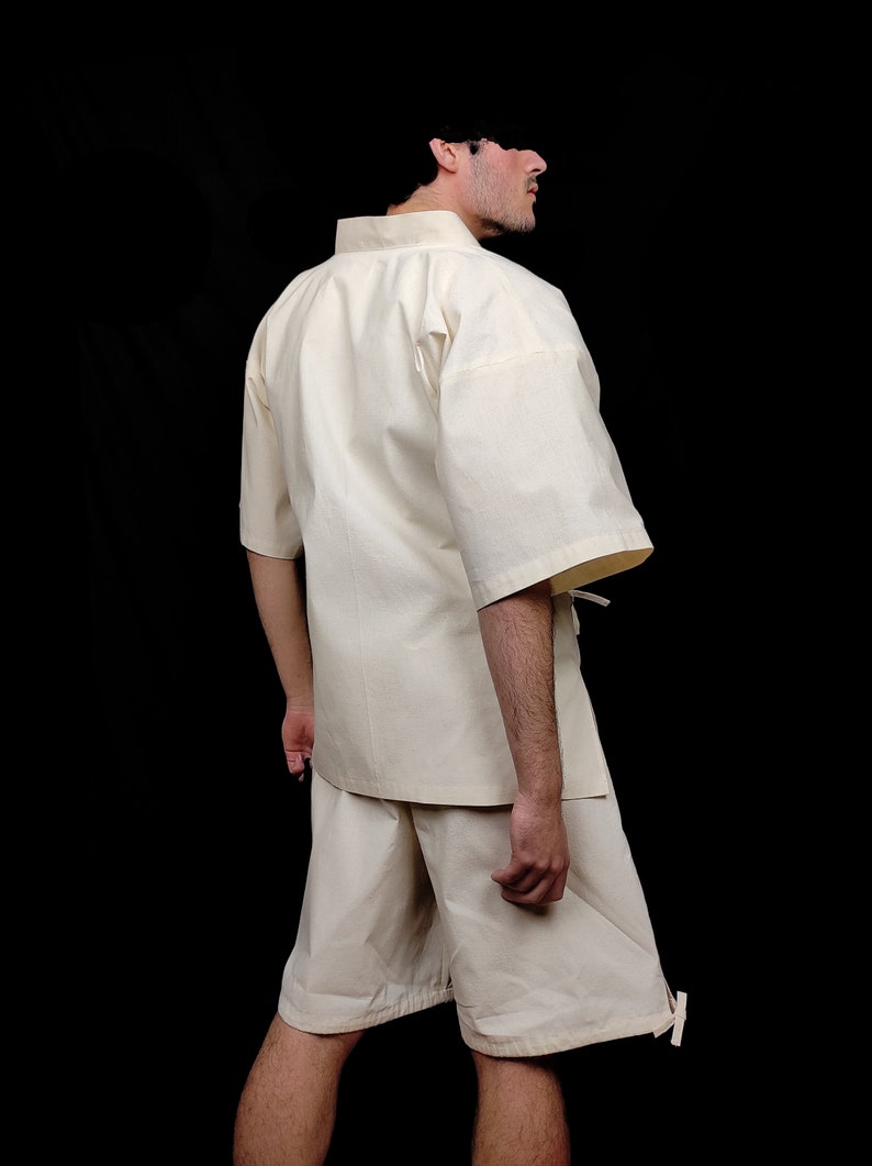 Puede incluir: Un conjunto de camisa y pantal&oacute;n corto color crema con mangas cortas. La camisa tiene cuello mandar&iacute;n y corte holgado. El pantal&oacute;n corto llega a la rodilla con cintura con cord&oacute;n. El conjunto es de tejido ligero.
