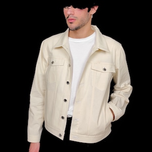 May include: A cream colored denim jacket with a button closure and two flap pockets. The jacket has a classic style and is made of a soft, comfortable fabric.