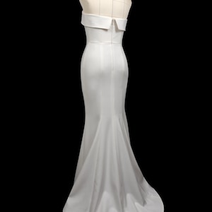 May include: A white strapless mermaid-style wedding dress with a fitted bodice and a flowing skirt.