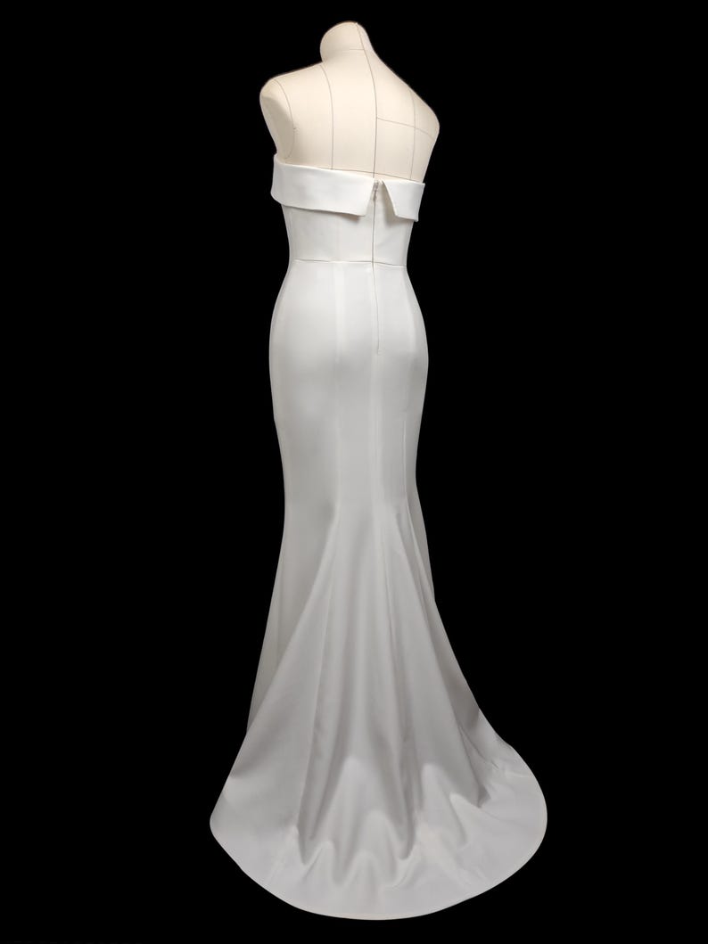 May include: A white strapless mermaid-style wedding dress with a fitted bodice and a flowing skirt.