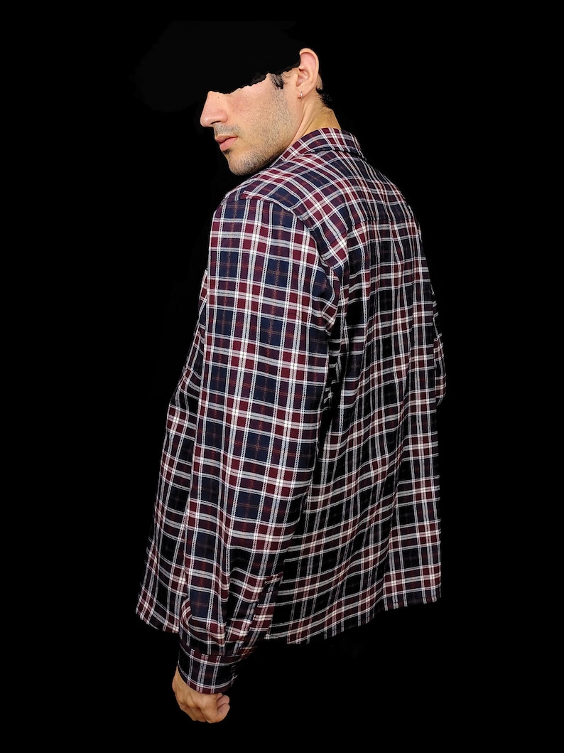 May include: A long-sleeved plaid shirt with a red, white and blue pattern. The shirt has a button-down collar and a relaxed fit.