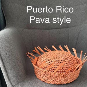 May include: A woven, peach-colored hat and basket set. The hat is round with a fringed brim, and the basket is a matching peach color. The text "Puerto Rico Pava style" is displayed in white.