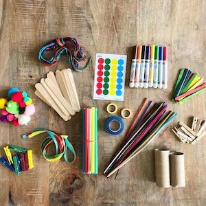 Op de afbeelding: Een verzameling kleurrijke knutselspullen, waaronder pompoenen, garen, houten stokjes, rietjes, pijpenragers, tape, stiften en papieren cirkels.