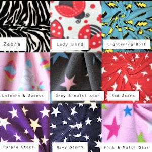 May include: A collection of nine fabric swatches featuring various patterns including black and white zebra stripes, red ladybugs, yellow lightning bolts on blue, unicorns, and stars in red, purple, navy, and multi-colored designs.