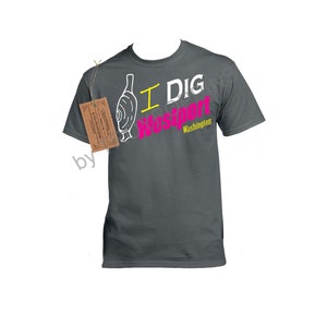 May include: A dark gray t-shirt with a white graphic of a clam and the text "I DIG Westport Washington" in pink and yellow.