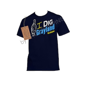 May include: A navy blue t-shirt with a white graphic of a bottle and the text "I Dig Grayland Washington".