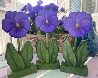Wooden hand painted pansies. Ready for spring to summer decorating. Each pansy is painted on both sides. They are sold in a set of three.