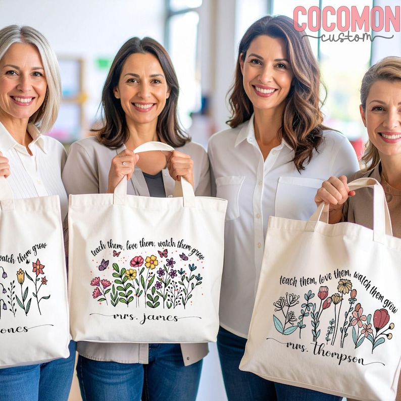 May include: Four women holding white tote bags with floral designs and the text "teach them, love them, watch them grow." Each bag features a different floral arrangement and a name. The bags have beige handles.