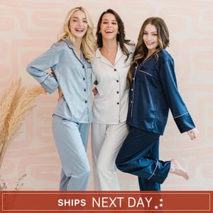 May include: Three sets of long-sleeved button-down pyjama shirts and matching trousers in light blue, white, and navy blue. Each set features a notched collar, a single chest pocket, and contrasting piping along the edges. The text reads SHIPS NEXT DAY.