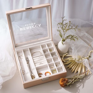 a jewelry box sitting on a table next to a flower