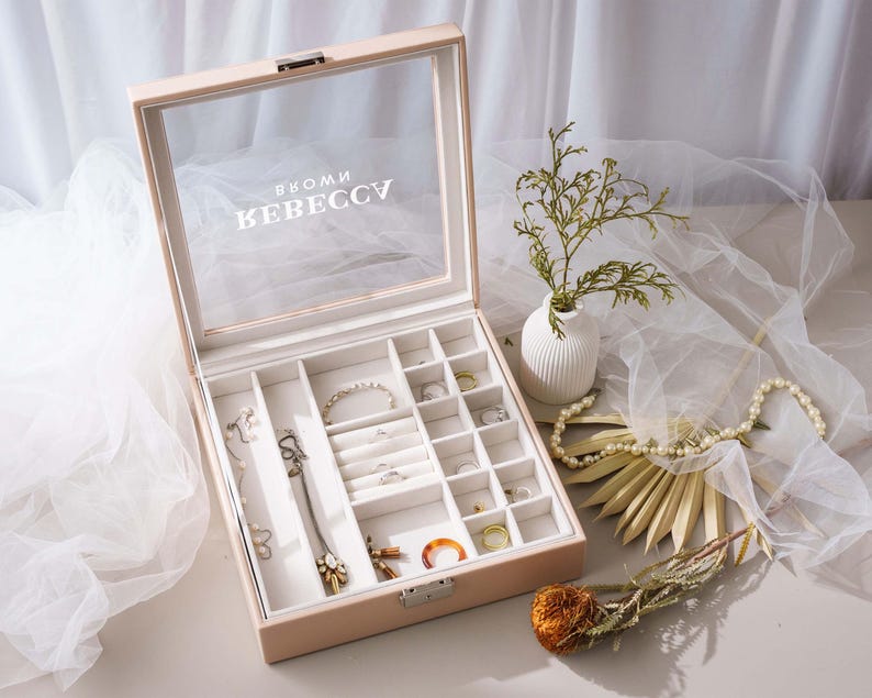 a jewelry box sitting on a table next to a flower