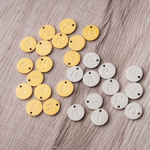 a pile of yellow and white name tags on a table