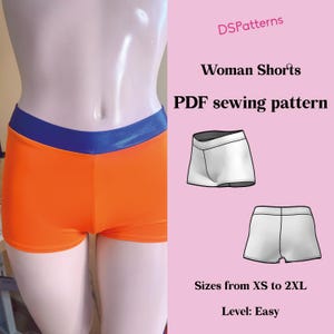 May include: Bright orange shorts with a blue waistband are shown on a mannequin. The image includes the text "Woman Shorts PDF sewing pattern" and "Sizes from XS to 2XL". The level is marked as "Easy".