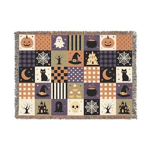 May include: A rectangular woven throw blanket featuring a patchwork grid of Halloween-themed illustrations including pumpkins, ghosts, black cats, witch hats, cauldrons, skulls, haunted houses, bare trees, spider webs, and tombstones in orange, purple, and black.