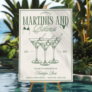 Może przedstawiać: Tablica na wiecz&oacute;r panieński z motywem martini i bikini na weekend. Tablica zawiera zielony tekst i ilustracje kieliszk&oacute;w do martini i bikini. Na niej widnieje napis "Weekend z martini i bikini" z tekstem "EST." i "2024" po obu stronach kieliszk&oacute;w do martini. Tablica zawiera r&oacute;wnież napis "Witamy na wieczorze panieńskim Katelyn Rose" oraz "Asheville, Karolina P&oacute;łnocna | 12 sierpnia - 15 sierpnia".