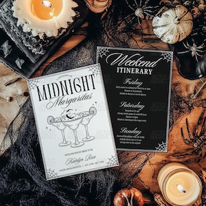 May include: Two invitation cards with a Halloween theme. One card reads "Midnight Margaritas" with margarita glasses. The other card is a weekend itinerary. The cards are on a wooden surface with candles, spiders, and pumpkins.