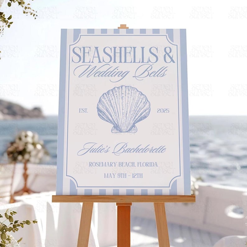 Op de afbeelding: Een blauw en wit gestreept bord met de tekst "Seashells & Wedding Bells" en een schelpgrafiek. Het bord bevat ook de tekst "Julie's Bachelorette", "Rosemary Beach Florida" en "May 9th - 12th".