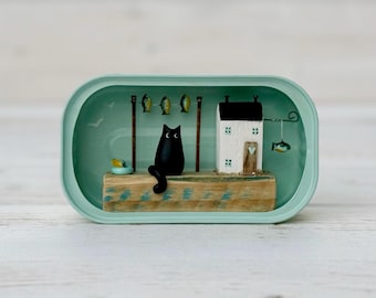 Sardine Tin Cat Cottage. Scena di tronchi trasportati dalla corrente.