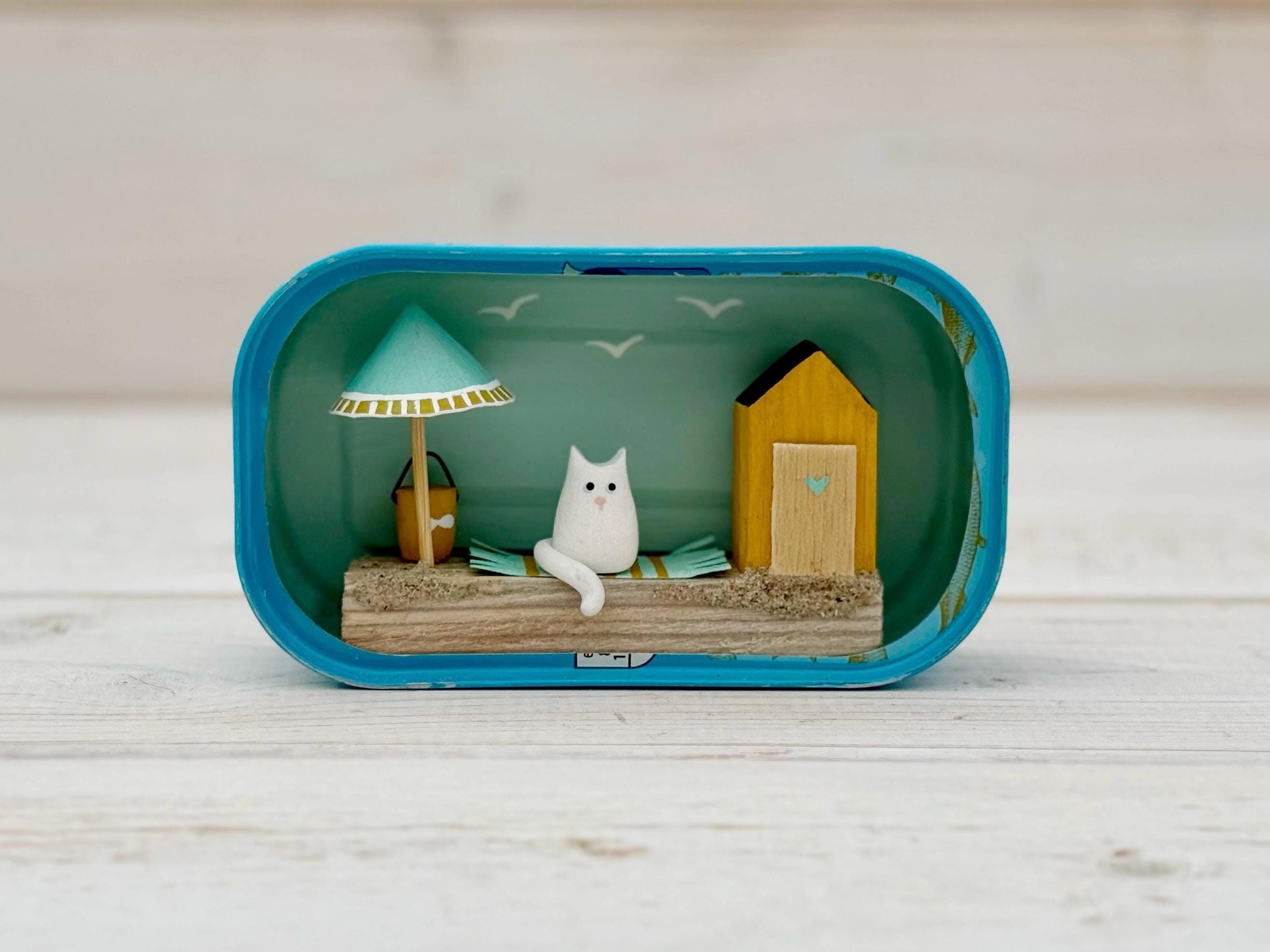 Paws on Holiday. Sardine Tin Cat Beach Driftwood Scene.