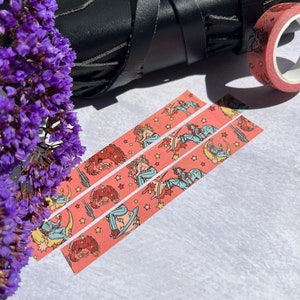 K&ouml;nnte beinhalten: Drei Rollen rosa Washi-Tape mit einem sich wiederholenden Muster einer Frau, die ein Pferd mit Sternen und einer Mondsichel reitet.