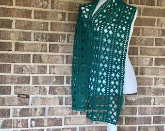 May include: A green crocheted scarf with a lacy pattern. The scarf is draped over a white dress form.