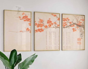 May include: Three framed prints of a traditional Japanese painting of a branch of a flowering tree with red blossoms. The prints are in gold frames and are hung on a white wall. The prints are arranged in a horizontal row.