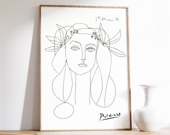 May include: Black and white line art print of a woman's face with a floral crown. The print is signed "Picasso" in the bottom right corner.