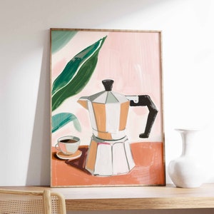May include: A framed art print depicting a coffee pot, a cup of coffee, and a large green leaf against a pink and orange backdrop. The coffee pot is silver, white, and orange. The art print is displayed on a wooden shelf.