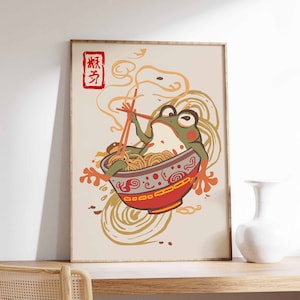 Peut inclure: Une grenouille verte assise dans un bol de nouilles rouge et blanc avec des baguettes. Le bol est entouré de nouilles tourbillonnantes et de vapeur. Le texte "辣" est écrit en rouge dans le coin supérieur gauche de l'image.