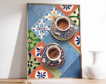 May include: Two cups of coffee on a colourful tiled surface. The cups are white with blue and gold designs. The tiles are a mix of blue, green, yellow, and red.
