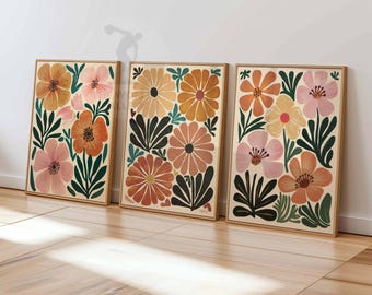 May include: Three framed floral prints with a retro style. The prints feature large, colorful flowers in shades of pink, orange, yellow, and green against a cream background.