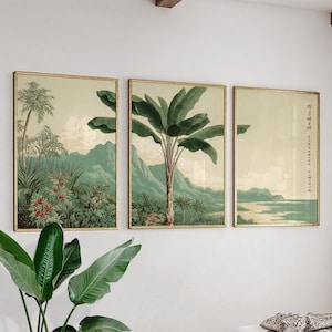 Può includere: Tre stampe botaniche incorniciate con cornici dorate. Le stampe raffigurano paesaggi tropicali con palme, vegetazione lussureggiante e montagne nelle tonalità del verde, beige e rosso. L'opera d'arte evoca un'estetica vintage.