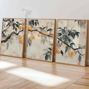 Puede incluir: Tres impresiones enmarcadas de una pintura de acuarela de una rama de árbol con hojas verdes y frutos naranjas. El fondo es de color beige claro.