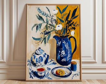 May include: A framed art print of a still life scene. A blue and white floral pitcher holds white flowers and greenery. A teapot, teacup, and plate with a pastry are on a floral tablecloth. The background is a mix of yellow and beige.