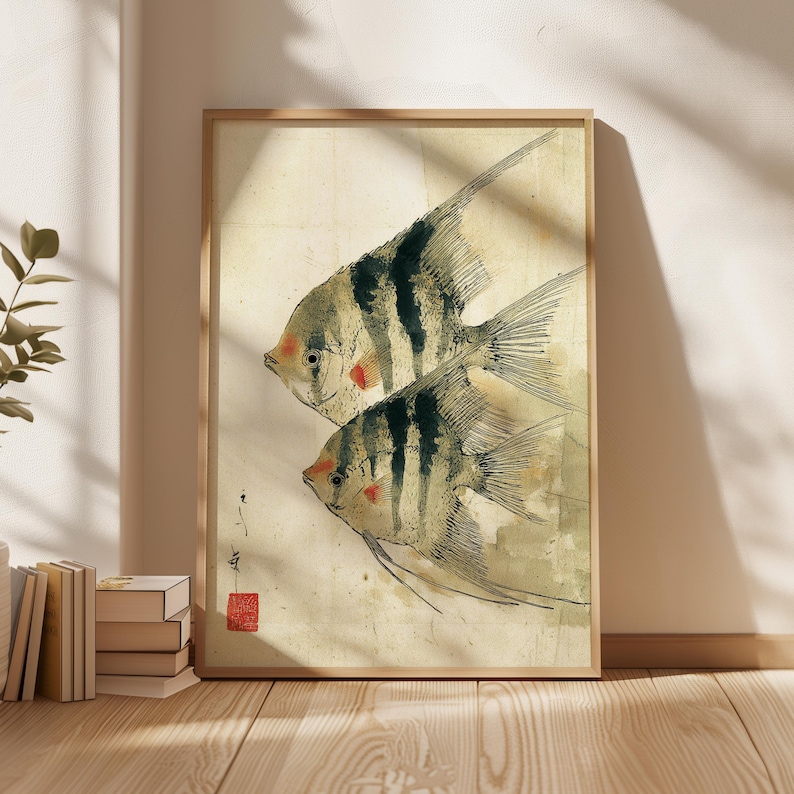 K&ouml;nnte beinhalten: Ein gerahmter Druck mit zwei stilisierten Fischen mit schwarz-wei&szlig;en Streifen, roten Akzenten und langen Flossen. Das Kunstwerk hat eine Vintage-&Auml;sthetik mit einem hellbeigen Hintergrund und einem Holzrahmen. Der Druck enth&auml;lt japanische Schriftzeichen und ein rotes Siegel.