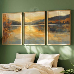 Peut inclure: Trois tableaux de paysage encadrés avec un cadre doré. Les tableaux représentent une scène de lac avec des arbres et de l'eau. Les couleurs sont des tons terreux et doux de brun, de vert et de bleu.