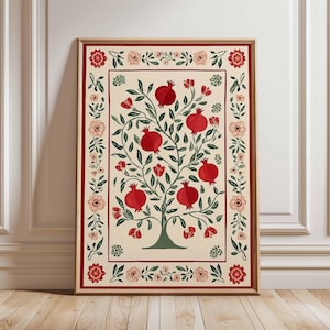 Puede incluir: Impresión artística enmarcada que representa un árbol de granada estilizado con frutos rojos y hojas verdes. La obra de arte está sobre un fondo crema, enmarcada por un borde rojo con detalles florales. El marco es de color marrón claro.