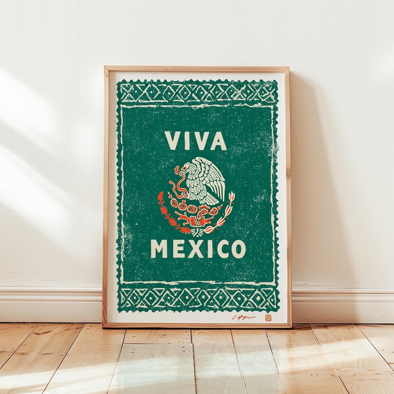 May include: A framed print featuring the Mexican coat of arms, with a green background and the words "VIVA MEXICO" in white. The print has a distressed, vintage look and is displayed on a wooden floor.