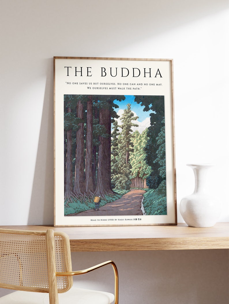 Op de afbeelding: Een ingelijste prent van een Japanse houtsnede die een pad door een bos toont. De prent is getiteld "Road to Nieko 119381 by Hasui Kawase" en bevat een citaat van Boeddha: "Niemand redt ons behalve onszelf. Niemand kan en niemand mag. We moeten zelf het pad bewandelen."