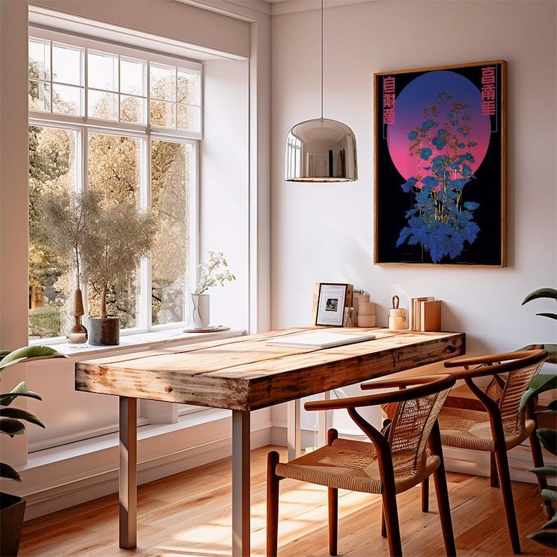 May include: A well-lit interior with a wooden desk and two chairs. A framed artwork with a blue and pink gradient and floral design hangs on the wall. A large window offers a view of trees. A silver pendant light hangs above the desk.